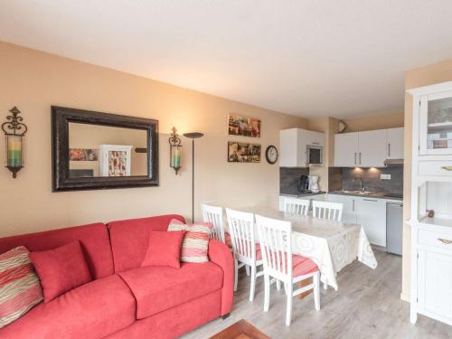 un salon avec un canapé rouge et une table dans l'établissement Appartement pour 6 pers. proche des pistes de ski - FR-1-296-375, à Saint-Lary-Soulan