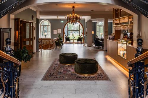 a living room with a chandelier and a table at Piteå Stadshotell in Piteå