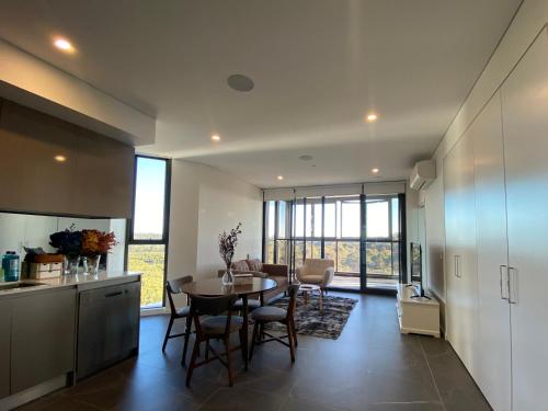 a kitchen and dining room with a table and chairs at Serene Parkside Retreat 2Brs@ close 2 Olympic park in Sydney