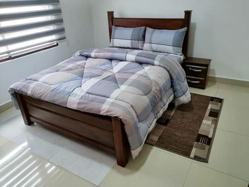 a bedroom with a large bed with a wooden frame at furnished 4 bd hse with pool in Accra