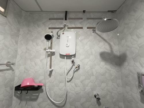 a shower in a bathroom with a pink stool at ROOMSTAY NIMAZA Bilik 1 in Marang