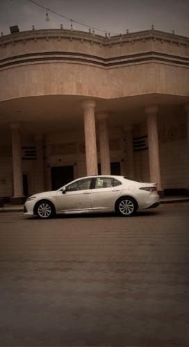 une voiture blanche garée devant un bâtiment dans l'établissement جدة, à Khamis Mushait