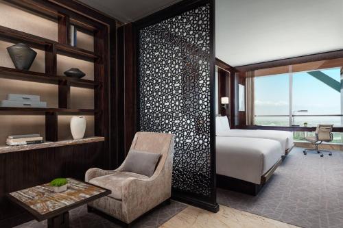 a bedroom with a bed and a chair and a desk at JW Marriott Hotel Yinchuan in Yinchuan