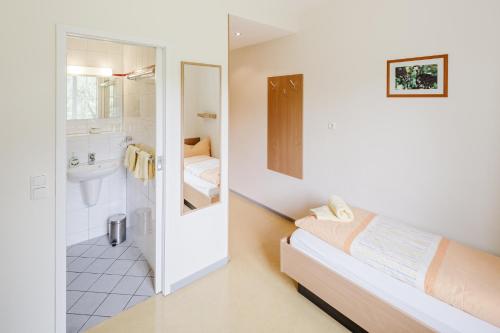 a white bathroom with a bed and a sink at Schacht III/ABZ in Gelsenkirchen