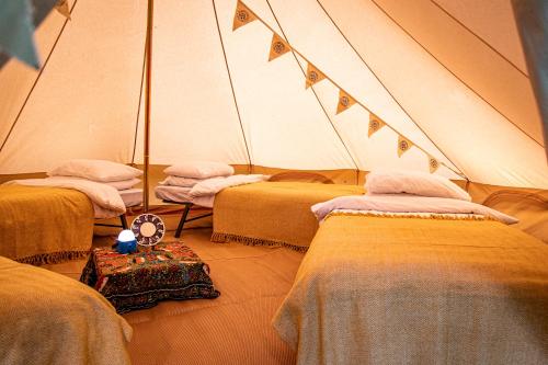 una habitación con 3 camas en una tienda de campaña en Avalon Boutique Camping @ The Crossways en North Wootton
