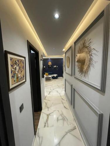 einen Flur mit weißen Marmorböden und Bildern an den Wänden in der Unterkunft Appartement Elégant in Casablanca