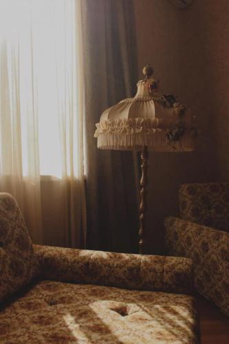 a lamp sitting next to a chair and a window at სასტუმრო ამელი/Hotel Ameli in Tʼelavi