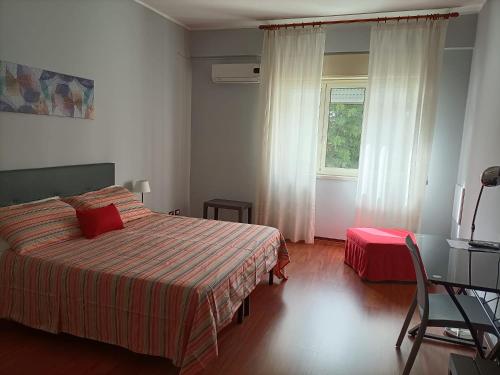 1 dormitorio con 1 cama, 1 silla y 1 ventana en B&B Maltese en Palermo