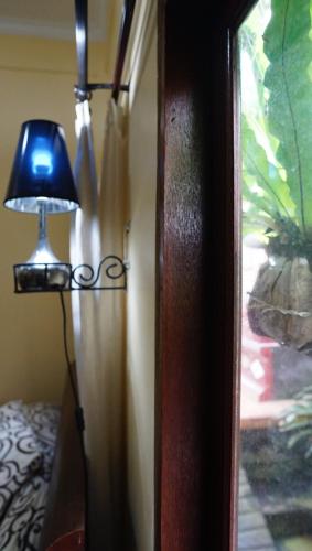 a lamp sitting next to a room with a window at Wahwik's House in Ubud