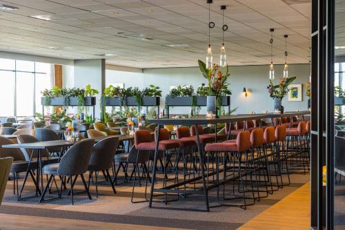 un restaurant avec des tables et des chaises ainsi qu'un bar dans l'établissement Postillion Utrecht Bunnik, à Bunnik