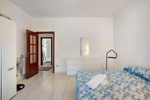 Dormitorio blanco con cama y pasillo en Casa Martina en Giugliano in Campania