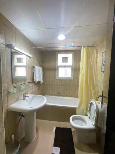 a bathroom with a sink and a toilet and a tub at Marbella Holiday Homes - Al Nahda in Dubai