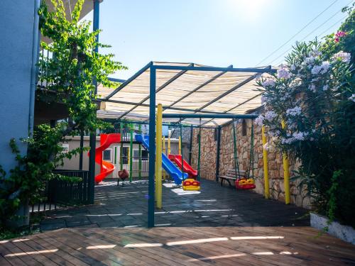 a playground with a canopy and a slide at Bodrum Beach Resort in Gümbet