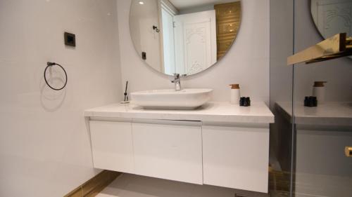 a white bathroom with a sink and a mirror at Jasmine Lodge Sapanca With Heated Pool in Serdivan