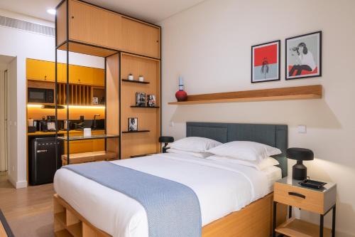 a bedroom with a large bed and a kitchen at BFRESH Hotel - Padel, Pool & Fitness - Adults Only in Porto