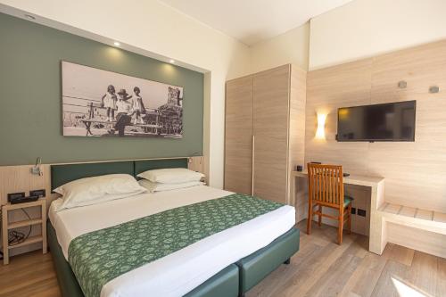 Cette chambre comprend un lit et une télévision. dans l'établissement Hotel Esperia, à Gênes