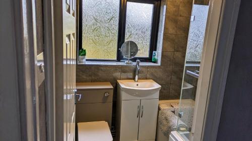 a small bathroom with a sink and a mirror at Summerhill, Wrexham - Key Worker friendly in Wrexham