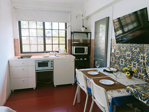 a kitchen with a table and a sink and a table and chairs at Casa em Palmela - Setúbal in Palmela