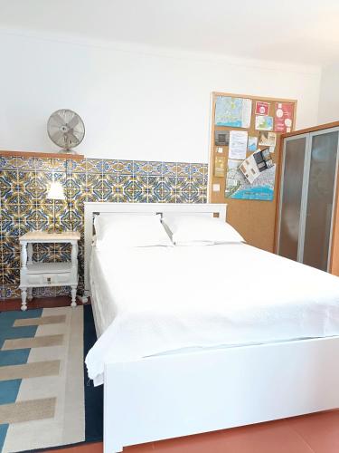 a white bed in a room with a wall at Casa em Palmela - Setúbal in Palmela
