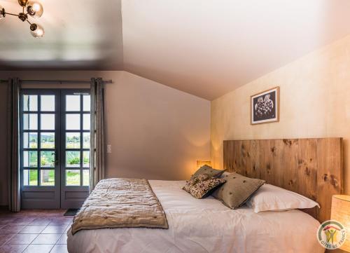 una camera con un grande letto con testiera in legno di Le Nid du Coucou 