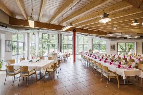 a banquet hall with white tables and chairs and windows at Schacht III/ABZ in Gelsenkirchen