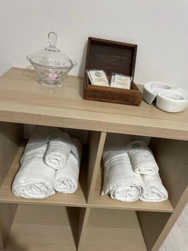 una mensola in legno con asciugamani e una scatola sopra di Casa Vacanza Rosati a Cerignola