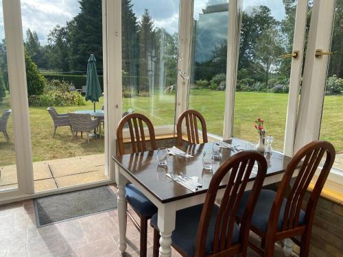 a dining room with a table and chairs and a window at Broom Hall Country Hotel in Saham Toney