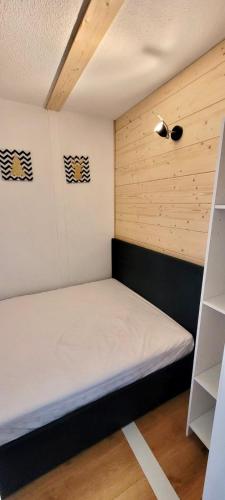 um pequeno quarto com uma cama num quarto em Appartement pied des pistes Puy Saint Vincent (05) em Puy-Saint-Vincent
