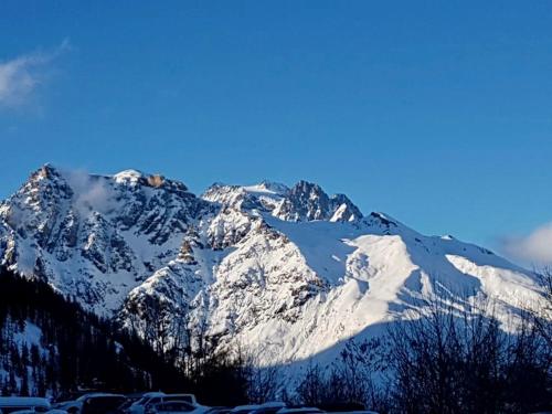 une montagne enneigée avec un ciel bleu en arrière-plan dans l'établissement Appartement pied des pistes Puy Saint Vincent (05), à Puy-Saint-Vincent
