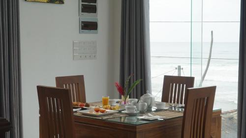 a dining room table with a view of the ocean at Surf View Resort in Ahangama