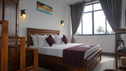 a bedroom with a bed and a large window at Surf View Resort in Ahangama