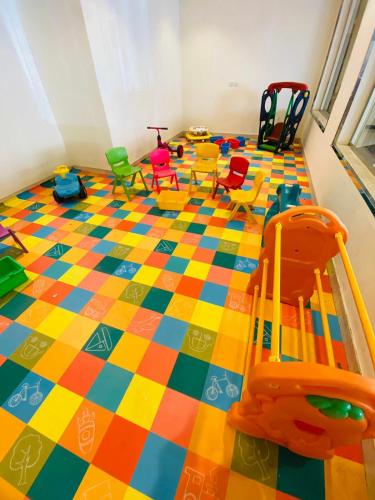 a play room with a checkered floor with colorful chairs at Towlan Khurais in Riyadh