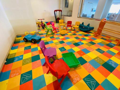 a room with chairs and toys on a colorful floor at Towlan Khurais in Riyadh