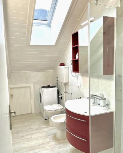 a bathroom with a sink and a toilet and a skylight at Appartamento Stella in Andalo