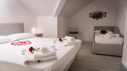 een slaapkamer met 2 bedden met handdoeken en bloemen erop bij Appartamento Stella in Andalo