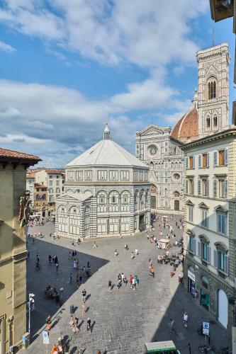 a group of people sitting in a plaza in front of a building at Duomo Luxury Florence in Florence