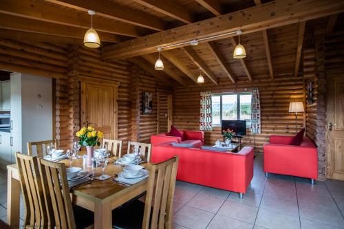 a living room with a table and red furniture at Mallard Lodge in Selby