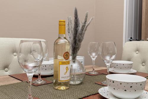 a bottle of wine sitting on a table with wine glasses at Finest Retreats - Peace Retreats in Pwllheli
