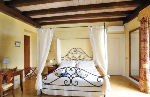 1 dormitorio con 1 cama blanca con dosel en Relais La Colombara Spa & Wellness, en Travo