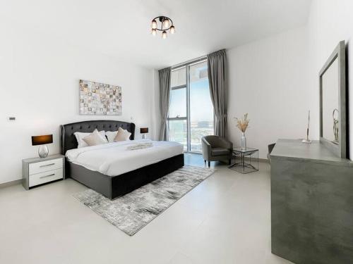 a bedroom with a bed and a chair and a window at StoneTree - Spacious 3 BR in The Pulse C2 in Dubai