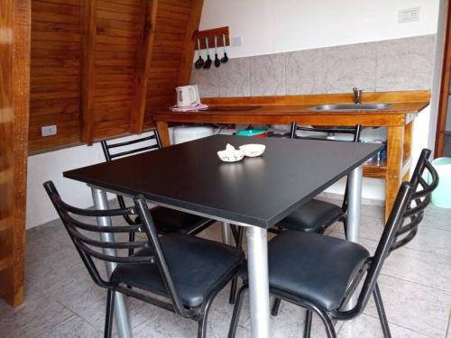 a dining room table with chairs and a sink at Amancay Cabaña alpina en Valle Fértil in San Agustín de Valle Fértil