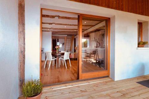 a glass door leading into a dining room with a table at Gîte Origin Gueberschwihr in Gueberschwihr