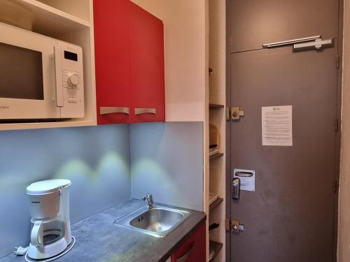 eine Küche mit einer Spüle und einer Mikrowelle in der Unterkunft Studio Plagne Aime 2000, 1 pièce, 4 personnes - FR-1-181-2585 in Aime La Plagne