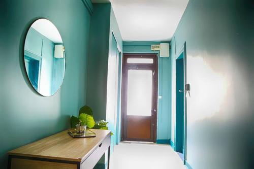 une salle de bain avec un miroir, une commode et une porte dans l'établissement L'écrin avec salle de sport, à Rouen