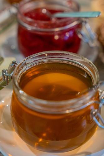 a glass jar of honey on a plate at Hotel Mazowiecki Łódź in Łódź