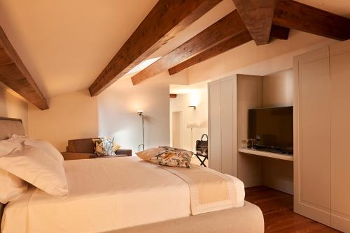a bedroom with a bed and a couch and a television at Relais - Palazzo Greco Stella in Lamezia Terme