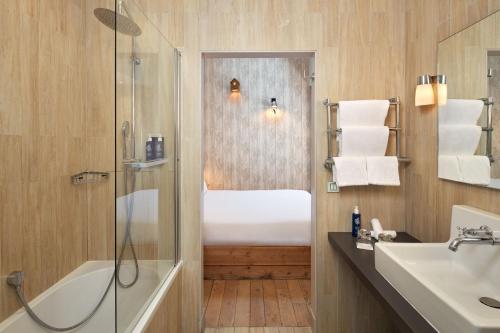 bagno con doccia e lavandino di Les Plumes Hotel a Parigi