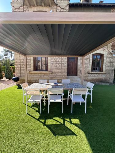 d'une terrasse avec des tables et des chaises sur une pelouse. dans l'établissement Maison de ville Duplex Artienzo, à Sarlat-la-Canéda