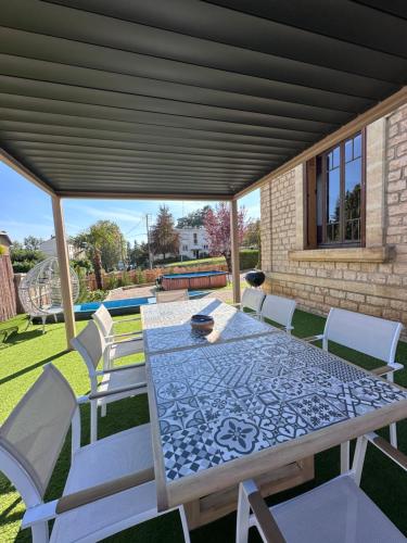 une table et des chaises sous une couverture sur une terrasse dans l'établissement Maison de ville Duplex Artienzo, à Sarlat-la-Canéda
