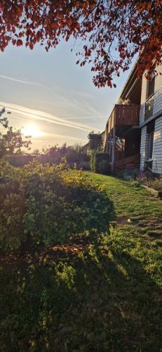 a house with the sun setting in a field at Katrins Ferienwohnung in Hammelburg